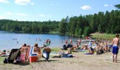 Människor som solar och badar en sommardag.