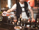 A man pouring up a glass of wine in a bar