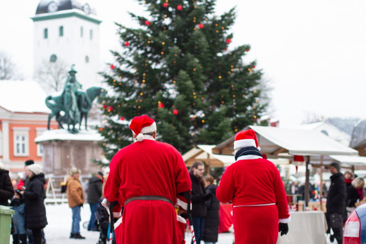 Tomtar vid julgran på ett torg 