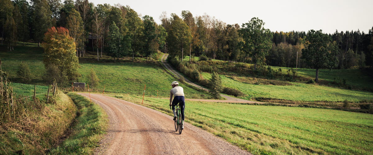 Cyclists on a dirt road in a working environment.