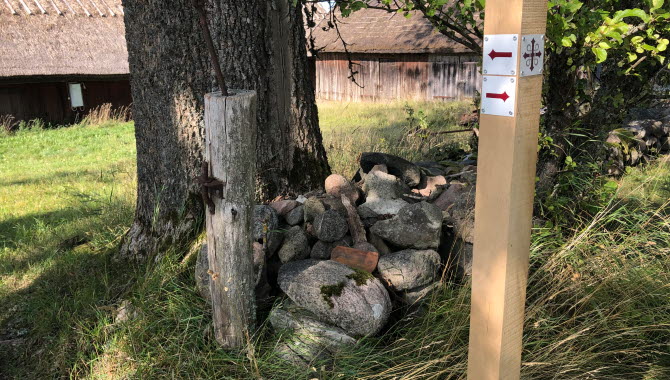 Stolpe i trä med pilgrimsmärket.