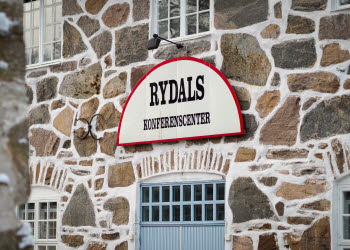 Skylt Rydals konferenscenter på vacker stenvägg