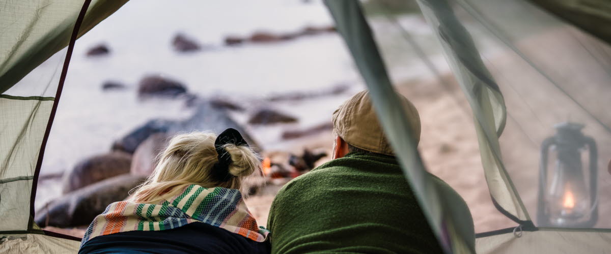 Couple in a tent on a Swedish beach, outside Hjo. 