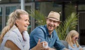 Two people sitting outside by a table and enjoying a fika