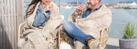 Man and woman on a balcony in an archipelago environment.