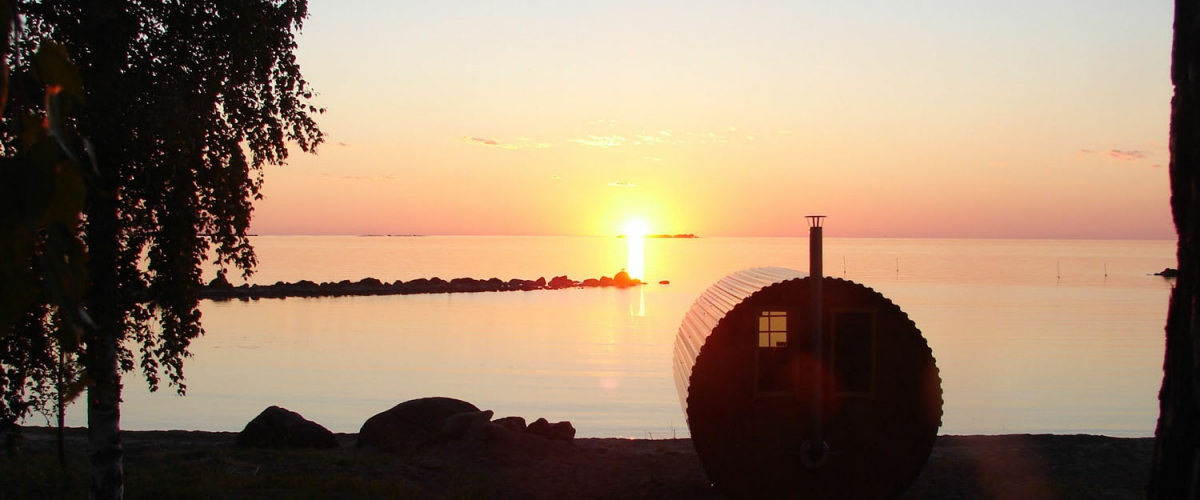 Bastun på Askeviks camping står precis vid Vänerns strand. Bilden är tagen på kvällen när solen precis går ner  vid horisonten.