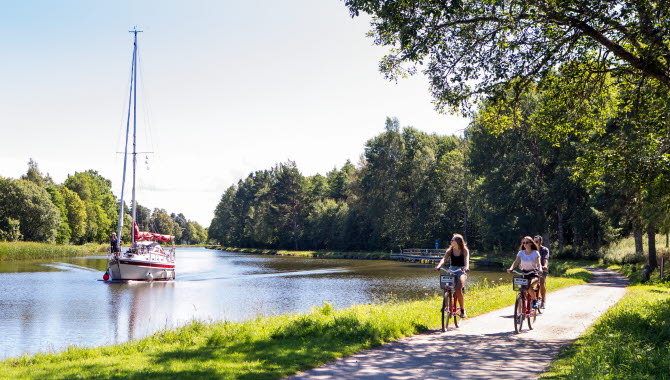 Cyklar längs Göta kanal. En båt i bakgrunden.