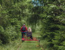 Two people on a railway push trolley.