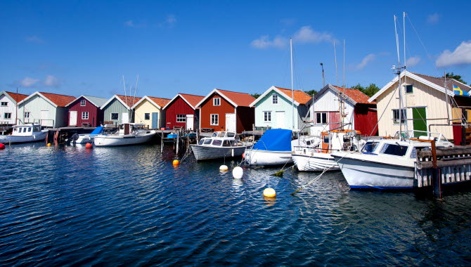 Färgglada sjöbodar med ankrade småbåtar vid bryggorna på Nordkoster.
