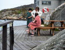 Family that has bathed and stands on a jetty wrapped in towels.