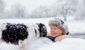 Vinterbadare med hund i snölandskap vid Simsjön i Skövde. 