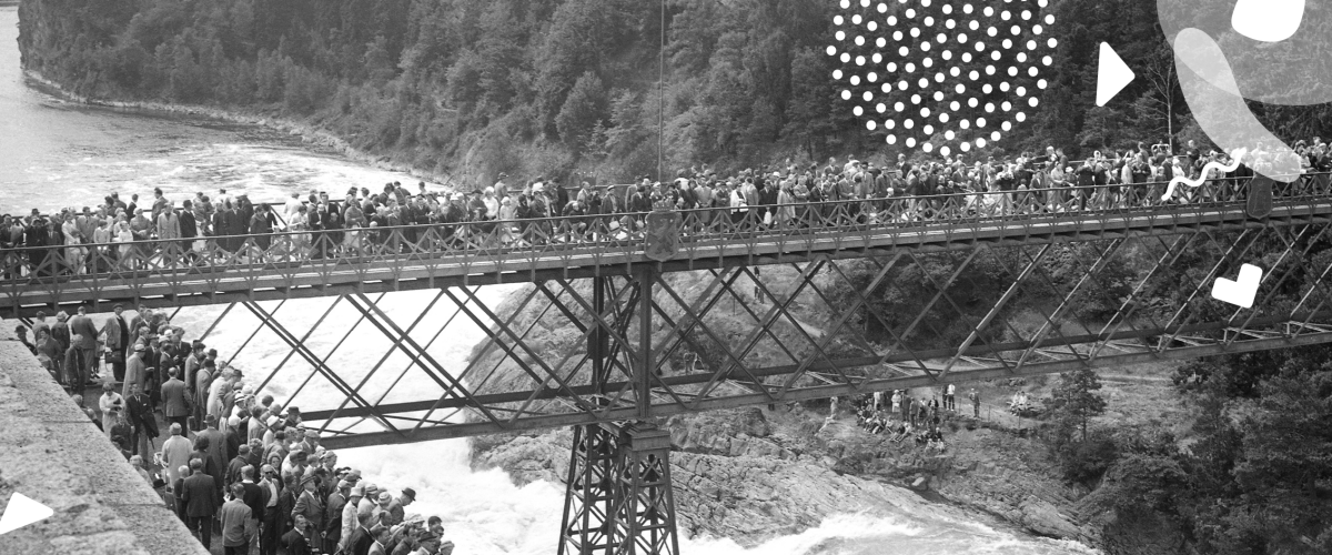 Svartvit bild på den gamla Oscarsbron fylld av människor som ser ett fallpåsläpp
