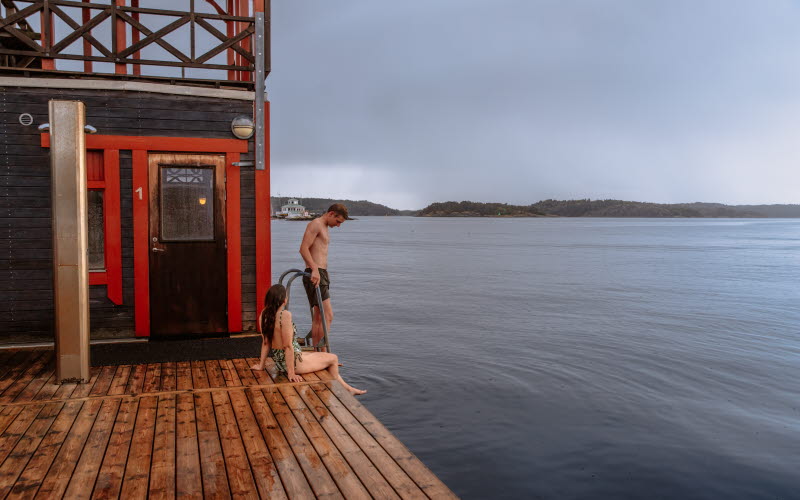 Två människor befinner sig i en skärgårdsmiljö.