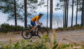 Kvinna cyklar på grusväg i Dalsland