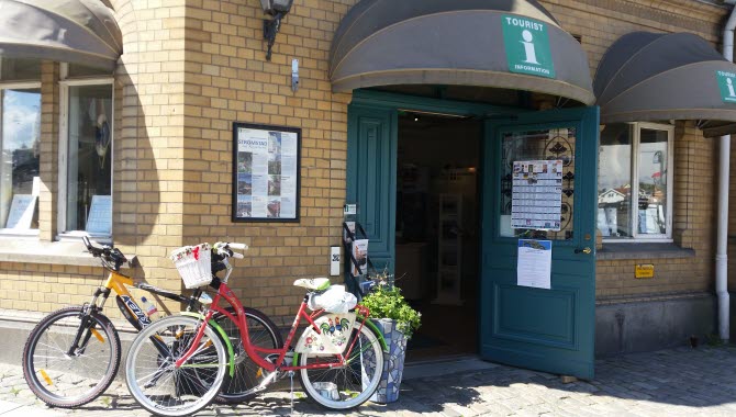 Entré till Strömstad turistbyrå, två cyklar står parkerade till vänster om entrédörren.