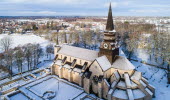 En stor stenkyrka och den intilliggande klosterruinen sedda från ovan. På marken ligger snö. 