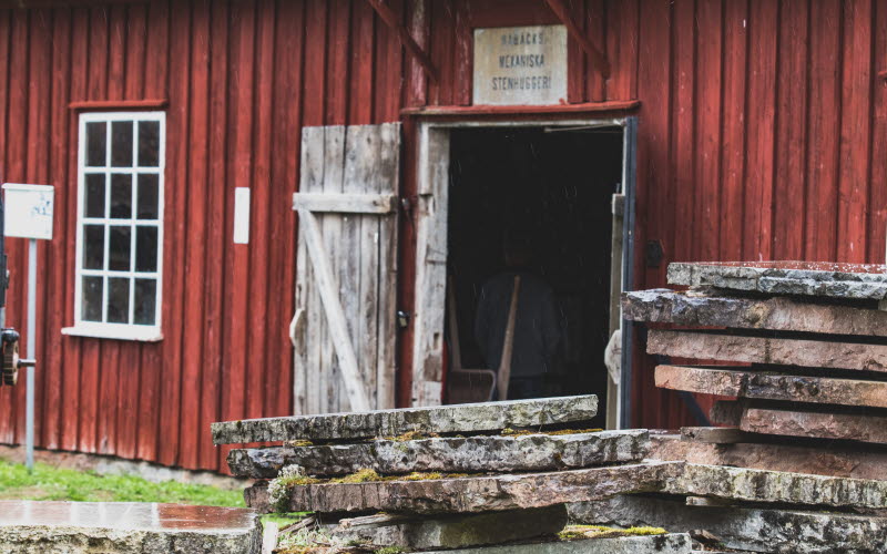 Fasad till stenhuggeri, staplade stenblock i förgrund