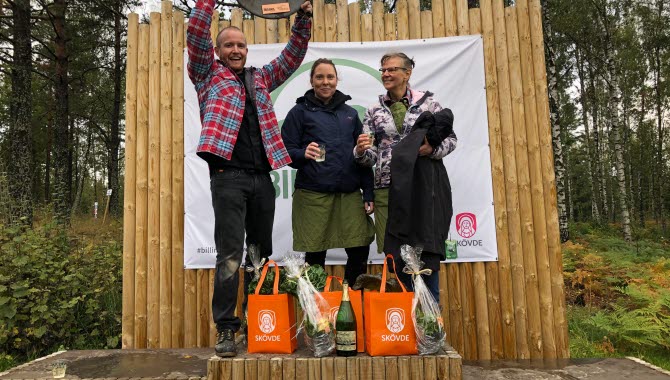 Tre personer står på en prispall utomhus. Personerna ler och är glada. De har vunnit SM i utomhusmatlagning 2020. Laget heter Maxime.