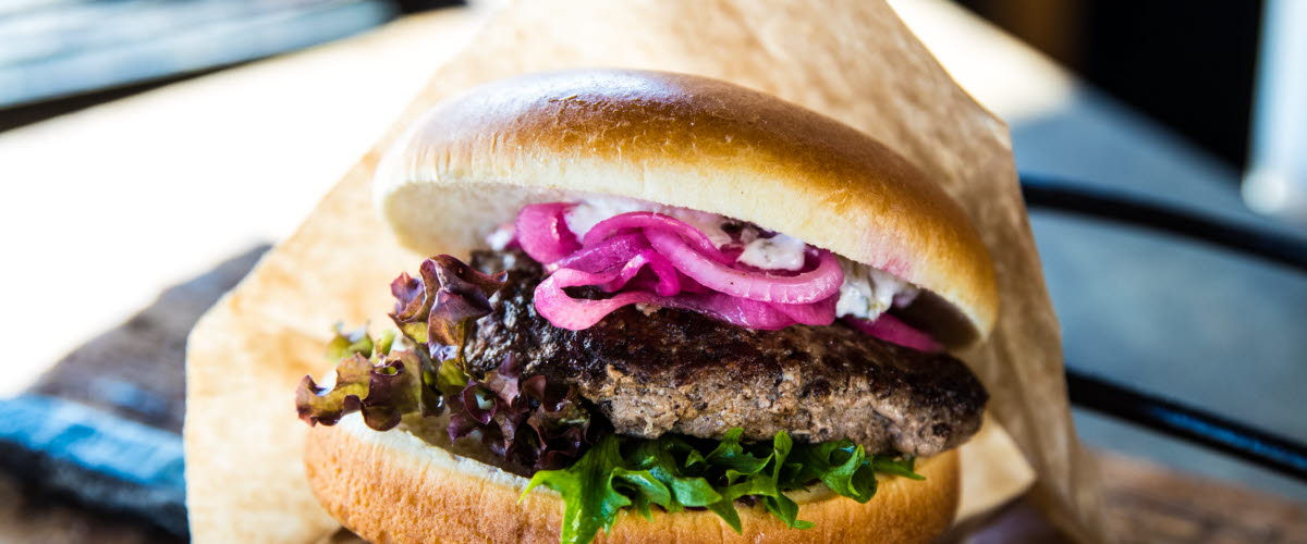 Hamburgare med bröd i ett pappershölje.