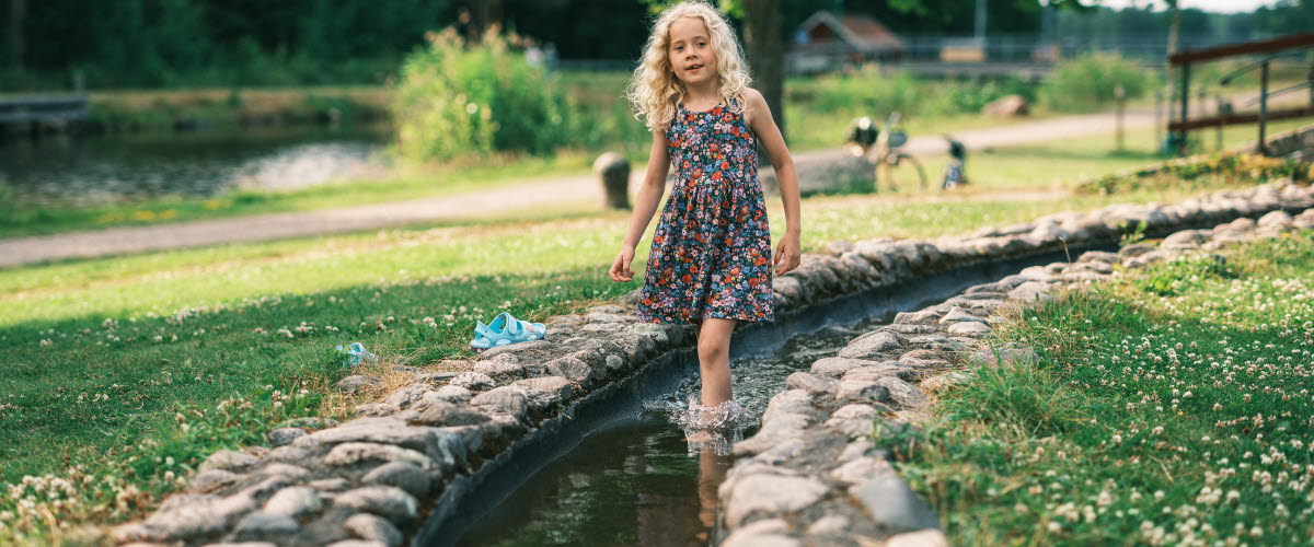 En flicka leker i minikanalen i Norrkvarn.