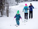 Familj med barn som åker längdskidor i skidspåret på Billingen. 