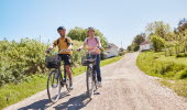 Two people are cycling on an island.