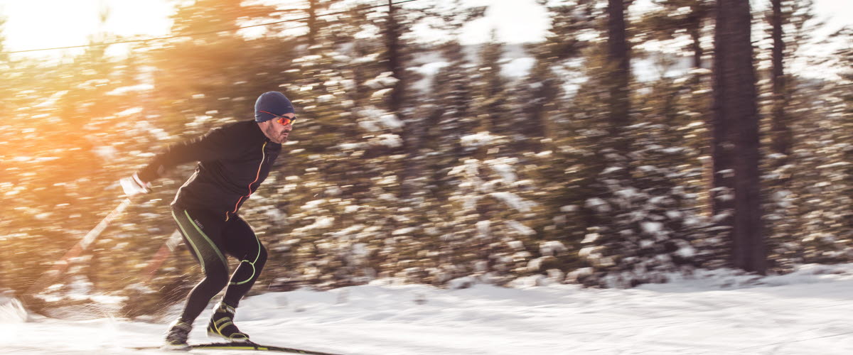 En skidåkare med fart tar sig fram på vit snö