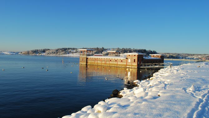 Strömstads kallbadhus en solig och klar vinterdag. Snö ligger på marken,