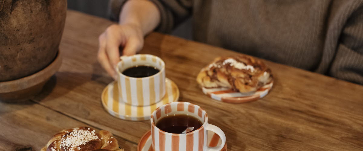 Kvinna håller i en kopp på ett kafé.