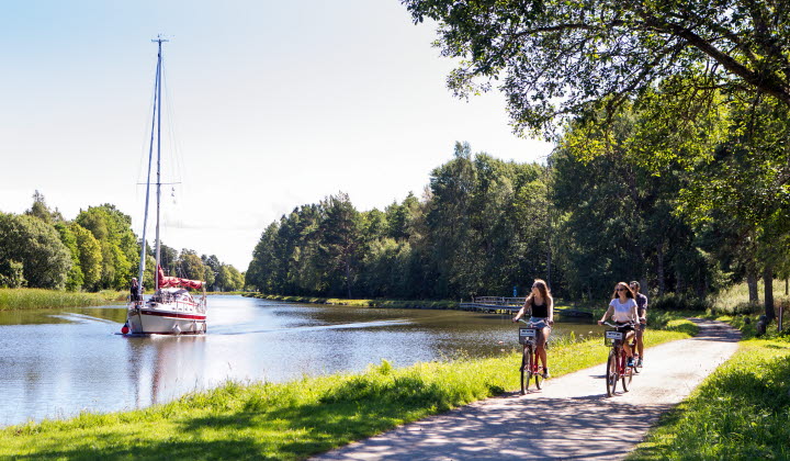 Cyklar längs Göta kanal. En båt i bakgrunden.