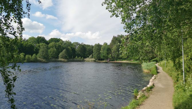 En badsjö inramad av lummiga omgivningar.