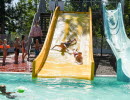 Children going down a slide into a pool