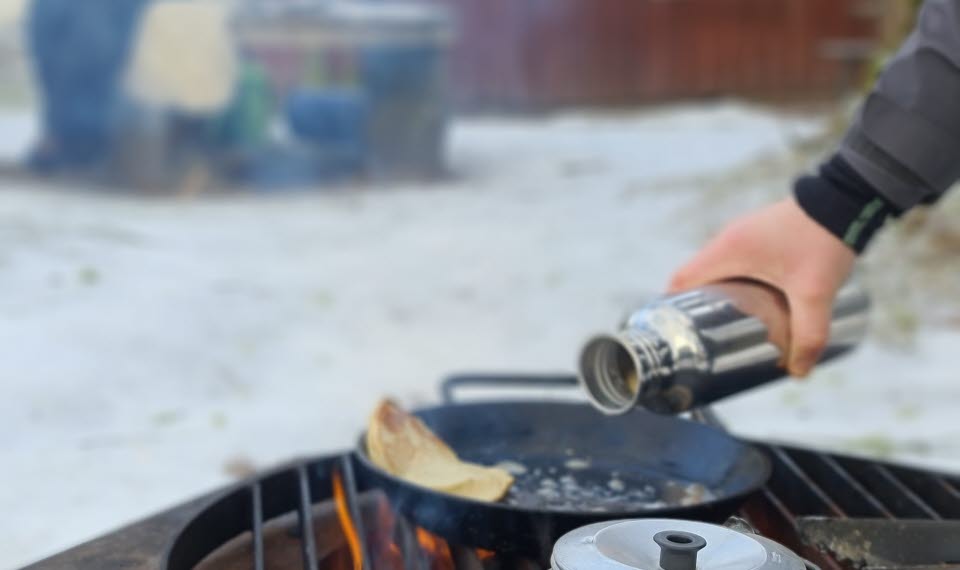 Matlagning över eldstad utomhus.