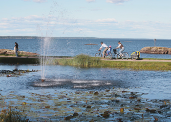 Två personer cyklar på en cykelbana precis vid Vänern.
