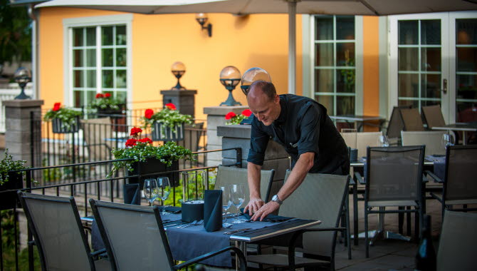 A man wipes a table at a restaurant
