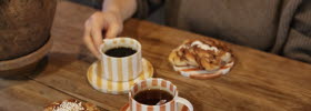 Woman holding a cup in a cafe.