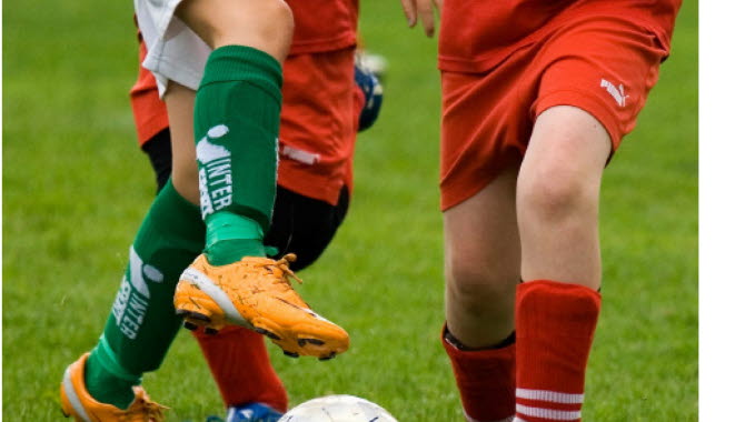 Ungdomar som sparkar fotboll.