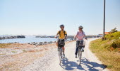 Two people are cycling on an island.