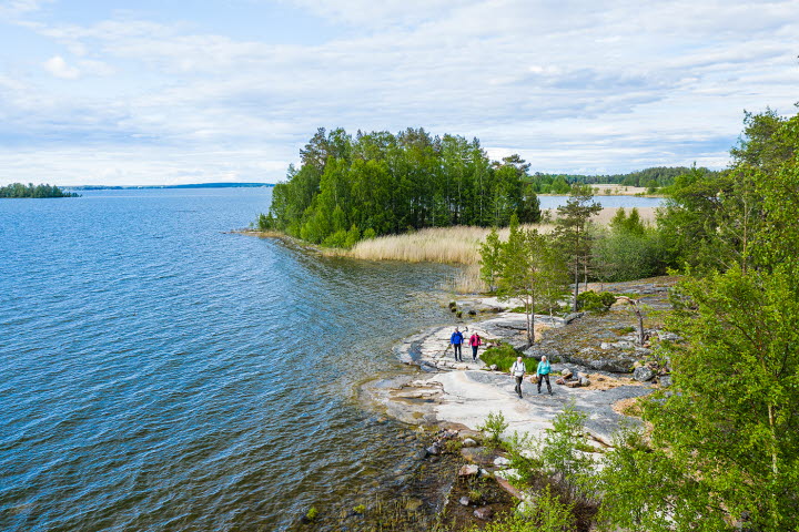 Four people hiking alonside lake Vänern in Mariestad.