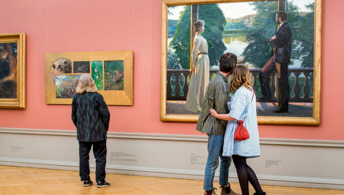 Persons looking at paintings.