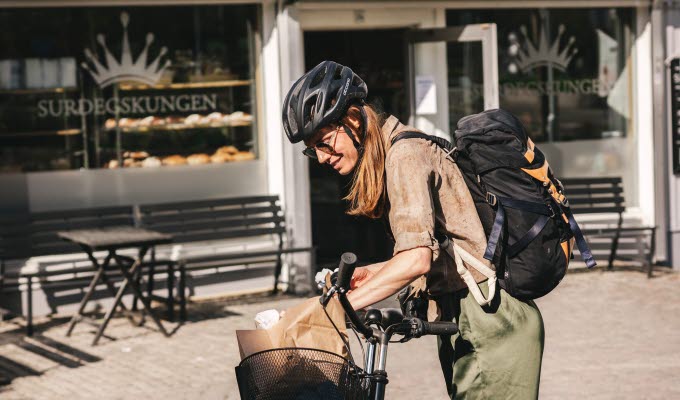 Woman by a bicycle who has bought sourdough buns.