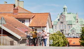 Två personer cyklar i en småstad.