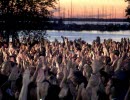 Audience with hands in the air, lake Vänern in the background.
