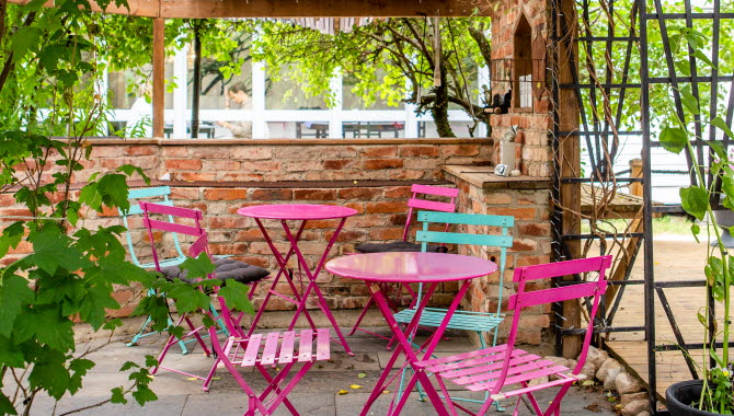 Mysig uteplats med färgglada stolar på Ådalens Café