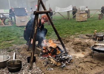 En kvinna lagar mat över öppen eld