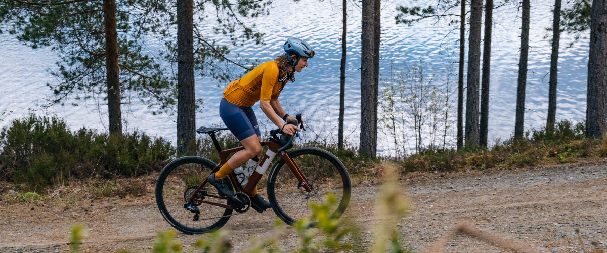 Kvinna cyklar på grusväg i Dalsland