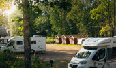 Campsite with mobile homes and red cabins.