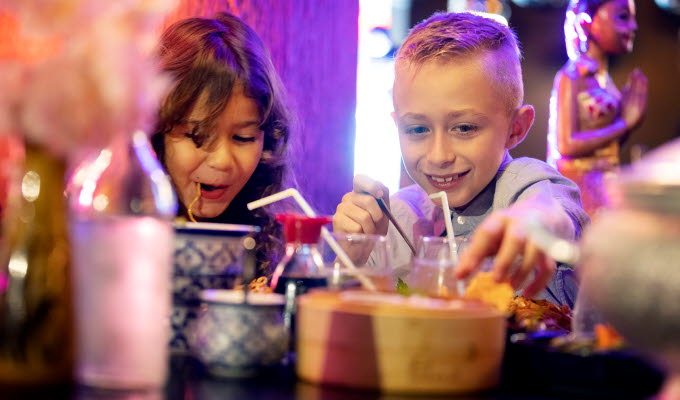 Two happy kids eating on a restaurant