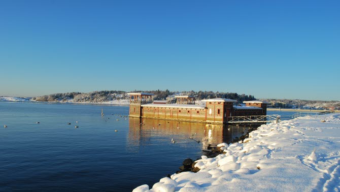 Strömstads kallbadhus en solig och klar vinterdag. Snö ligger på marken,