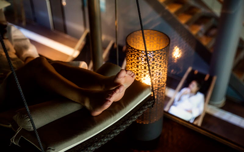 En tjej sitter i badstol med pool i bakgrunden